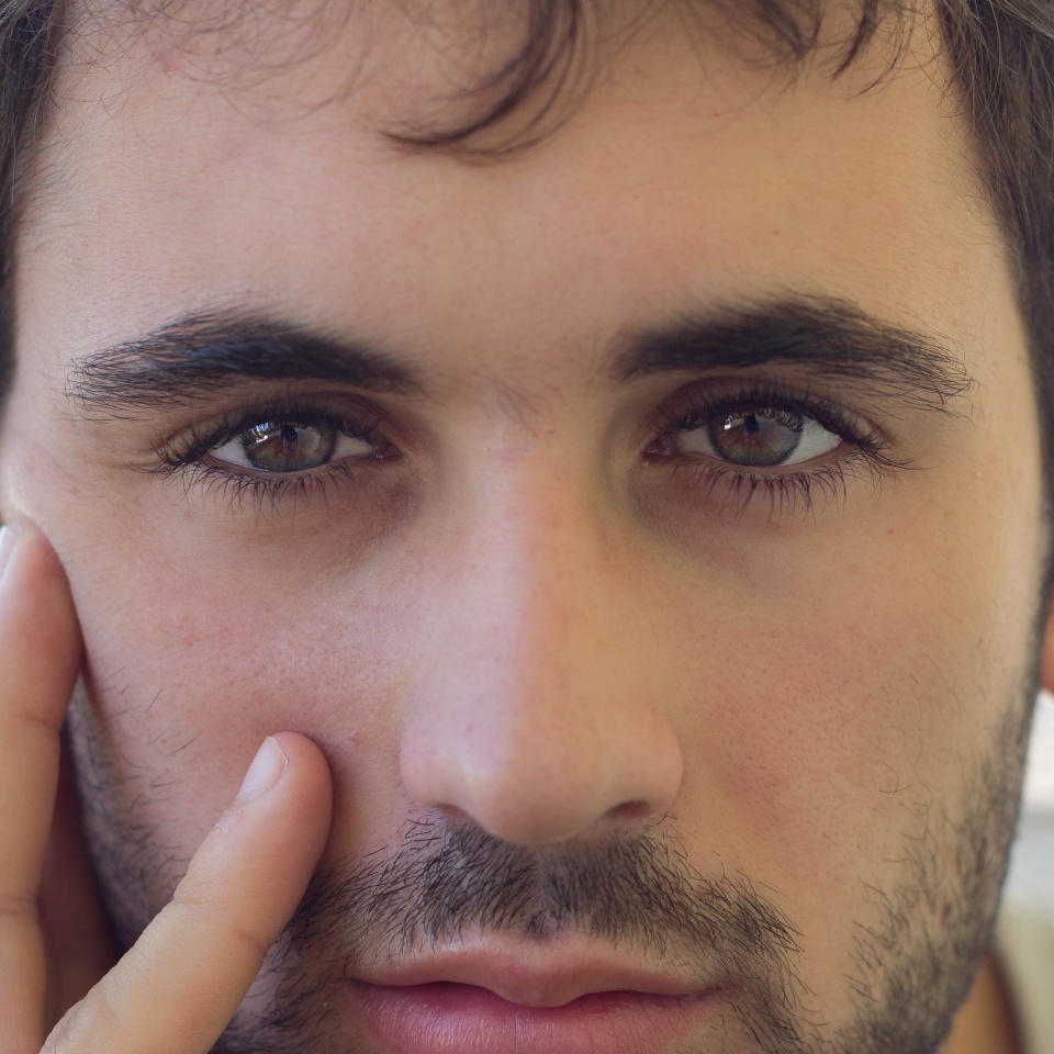 Close-up of caucasian boy with beard and clear eyes. Smiling expression Focus on the eyes
