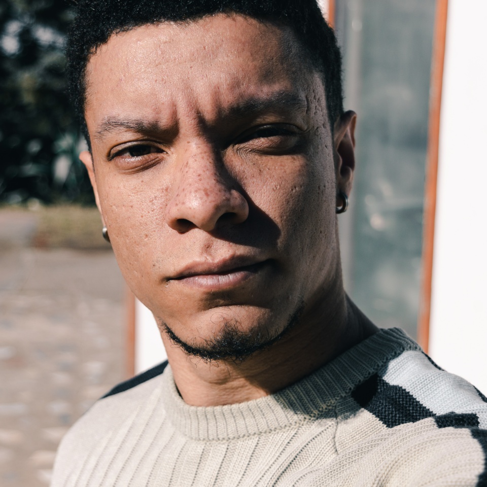 Close-up of young man with serious look and freckles on his face