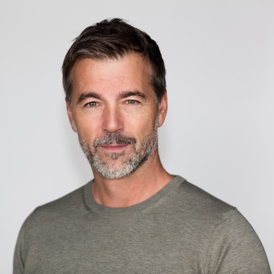 Portrait Of A Mature Man with a Little smile At The Camera. Right side of the picture.