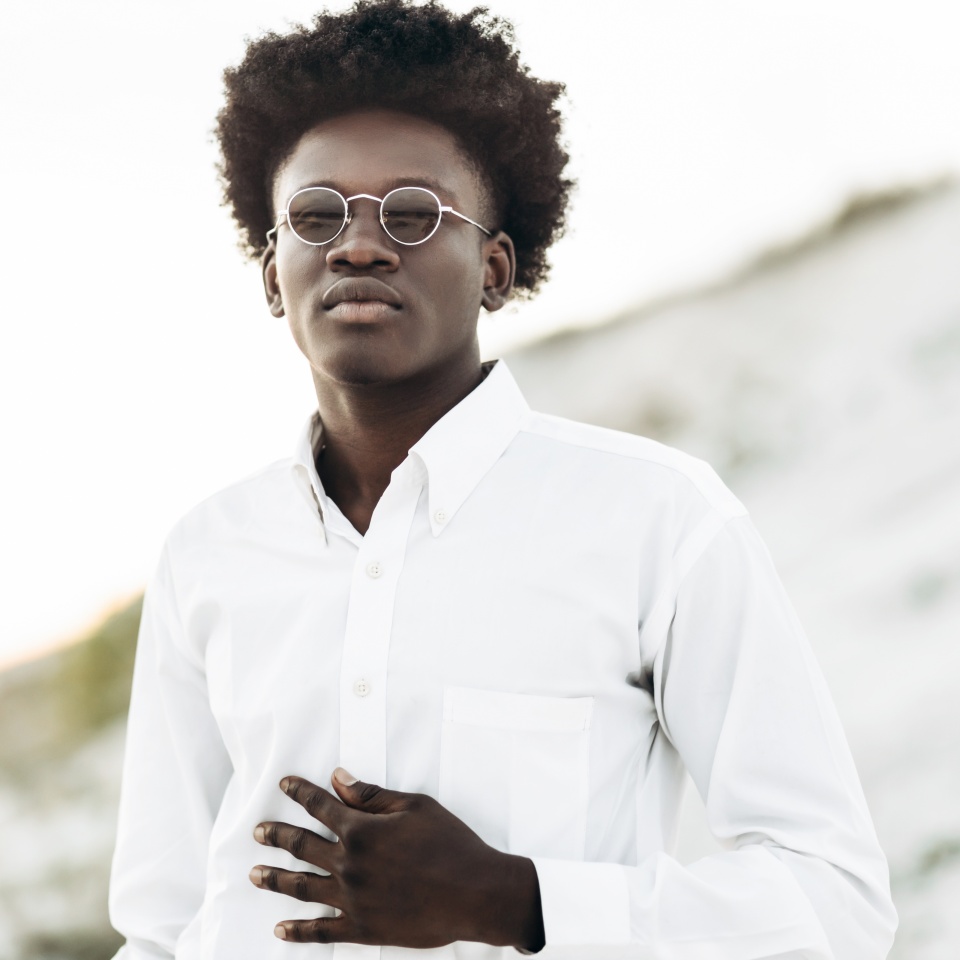 Man portrait, Handsome curly haired African American man, wearing white shirt and sunglasses, smiling outdoors