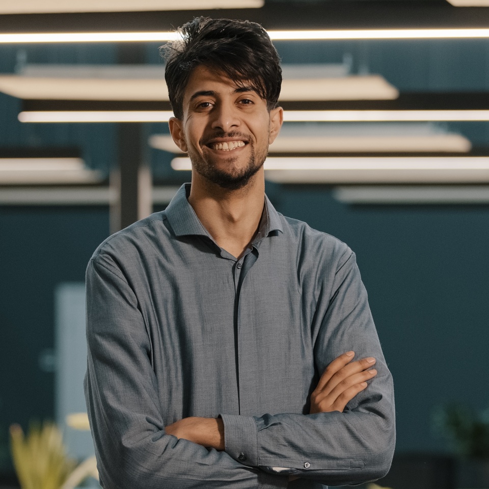 Portrait dreaming handsome millennial indian arabian young man hispanic guy businessman male worker analyst manager leader turn head looking at camera posing stand in modern office with crossed arms