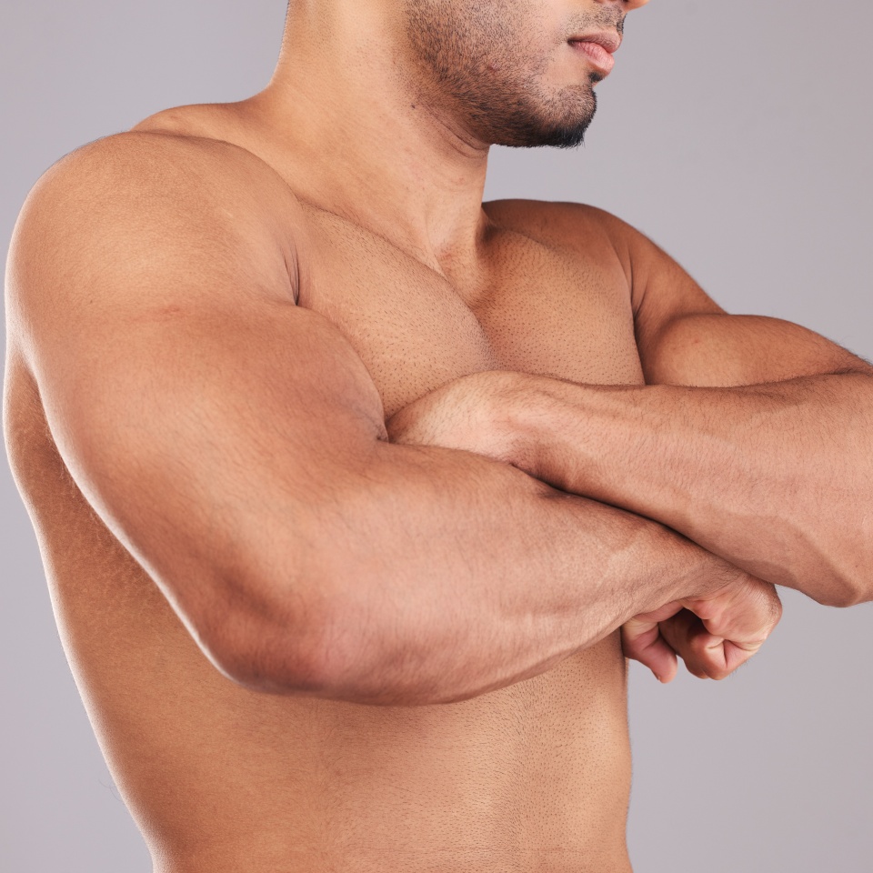 Strong, flex and man arms with muscle after training while standing in a studio with gray background. Power, motivation and closeup of athlete model with strength from bicep after workout or exercise