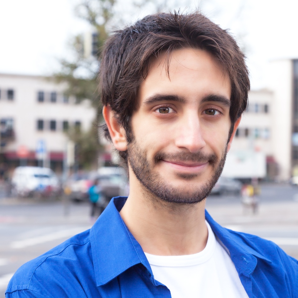 Smiling latin guy in a blue shirt in the city