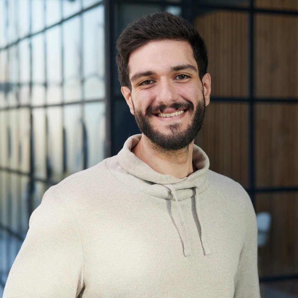Smiling young businessman in a sweater posing. Achieving career wealth business concept.