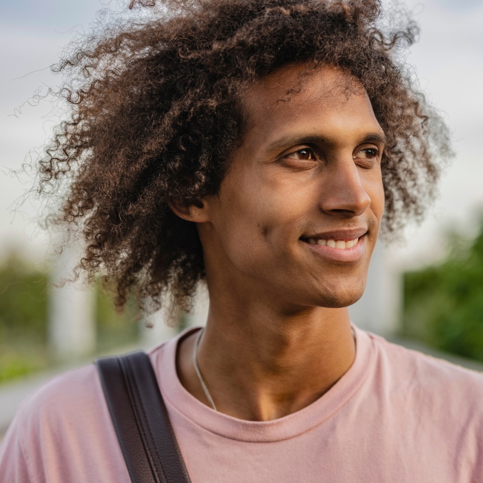 portrait of hispanic man with curly hair outdoors