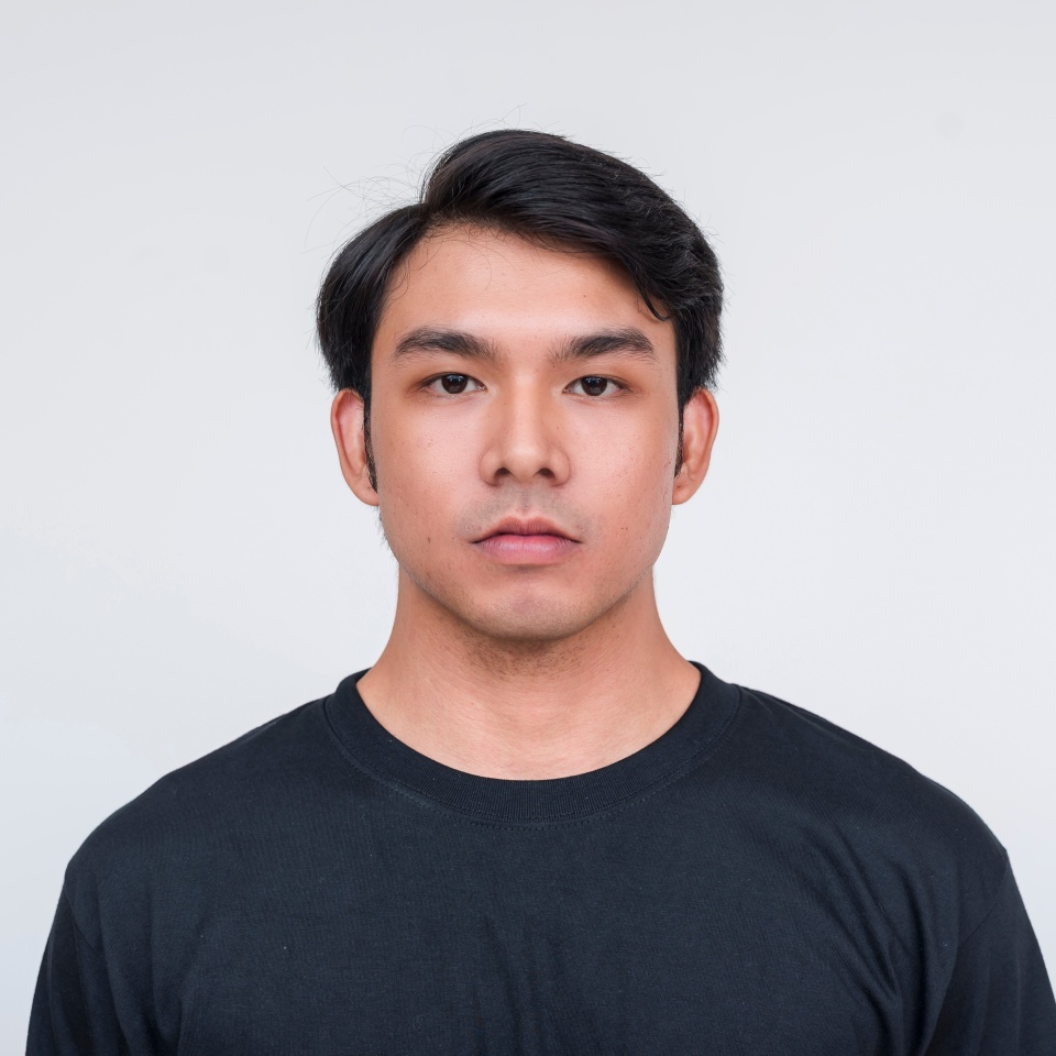 A portrait of a handsome young asian man wearing a black round neck shirt, isolated against a white background. Perfect for professional and casual themes.