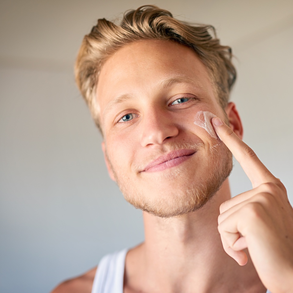 Face cream, skincare and portrait of man with natural, beauty and facial treatment at home. Smile, cosmetic and male person with dermatology sunscreen, lotion or spf for health routine in morning.