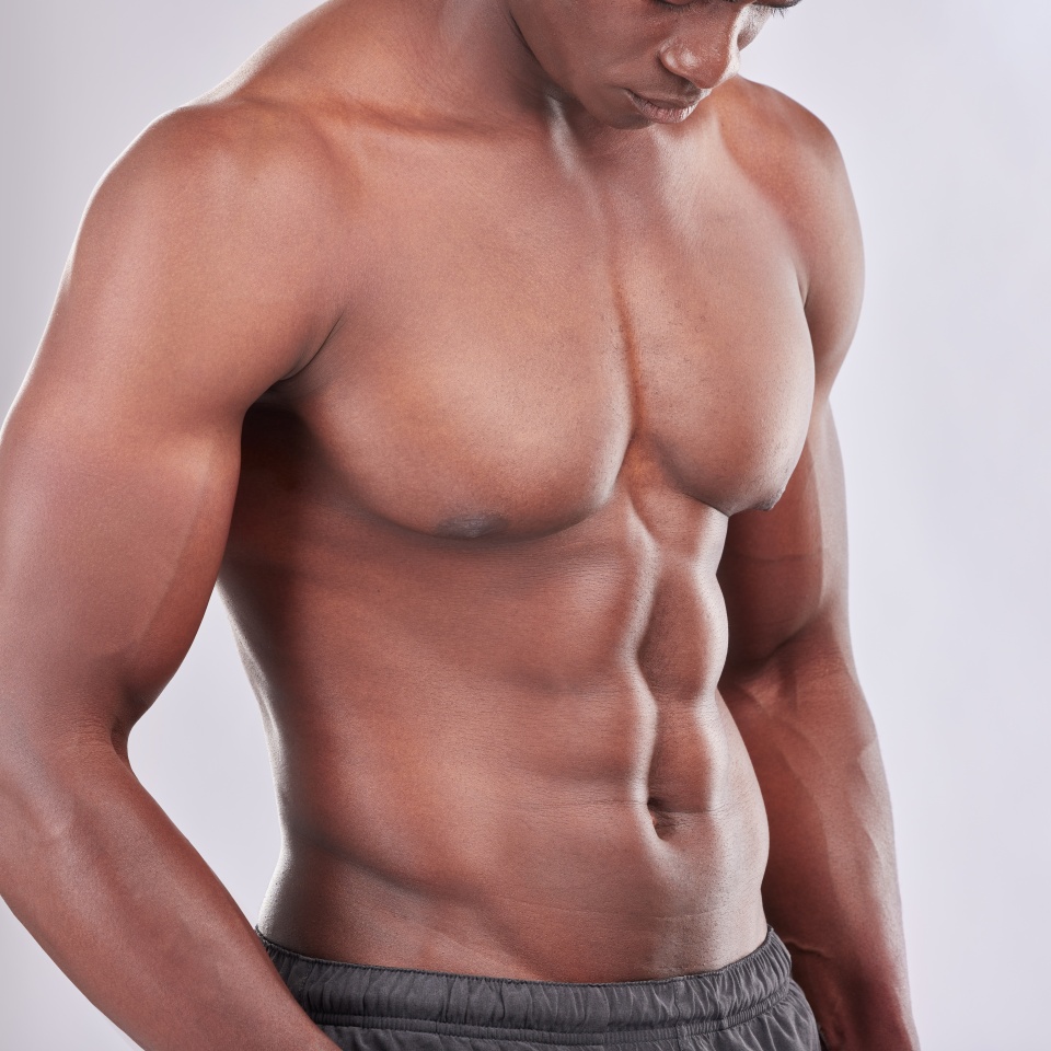 Stomach, muscle and black man for fitness with exercise and sports training in studio. African bodybuilder, strong body and abdomen with abs for wellness or health and six pack by white background