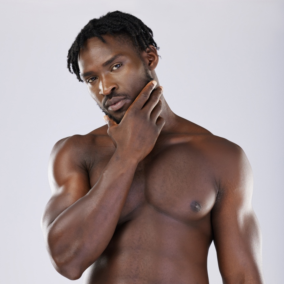 Black man, muscle and standing isolated on a grey background thinking, grooming or profile. Portrait of fit or attractive African American male, person or guy model in thought posing in the studio