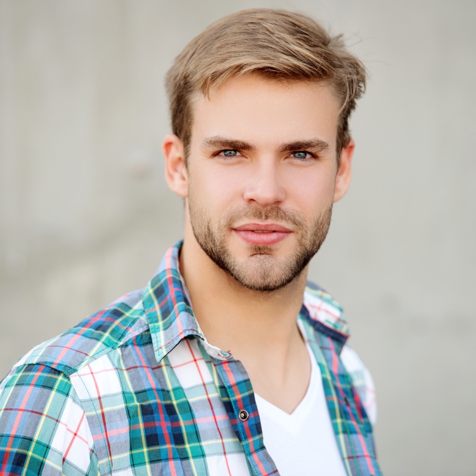 Portrait of man in casual style shirt. Stylish face portrait of unshaven guy. Handsome young man outdoor. Millennial man wearing checkered shirt. Casual style of millennial man