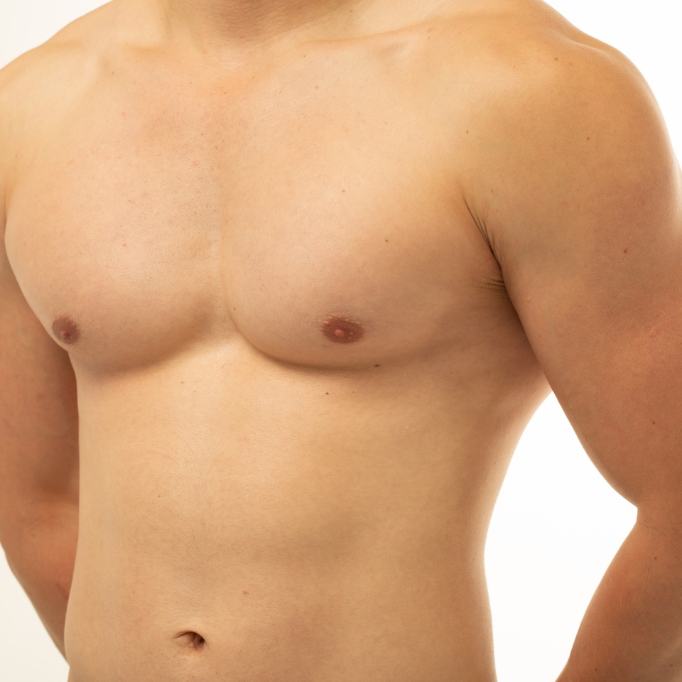 Young sportsman with athletic body posing in studio on isolated background. Smooth body after shaving. Firm torso after fitness gym. men's health: gastrointestinal diseases, gynecomastia