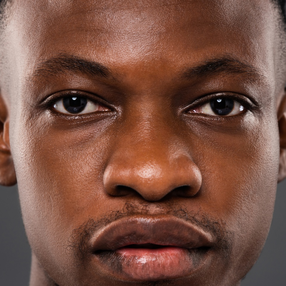 Close up portrait of African man face with eyes looking at camera showing strong expression and authentic detail