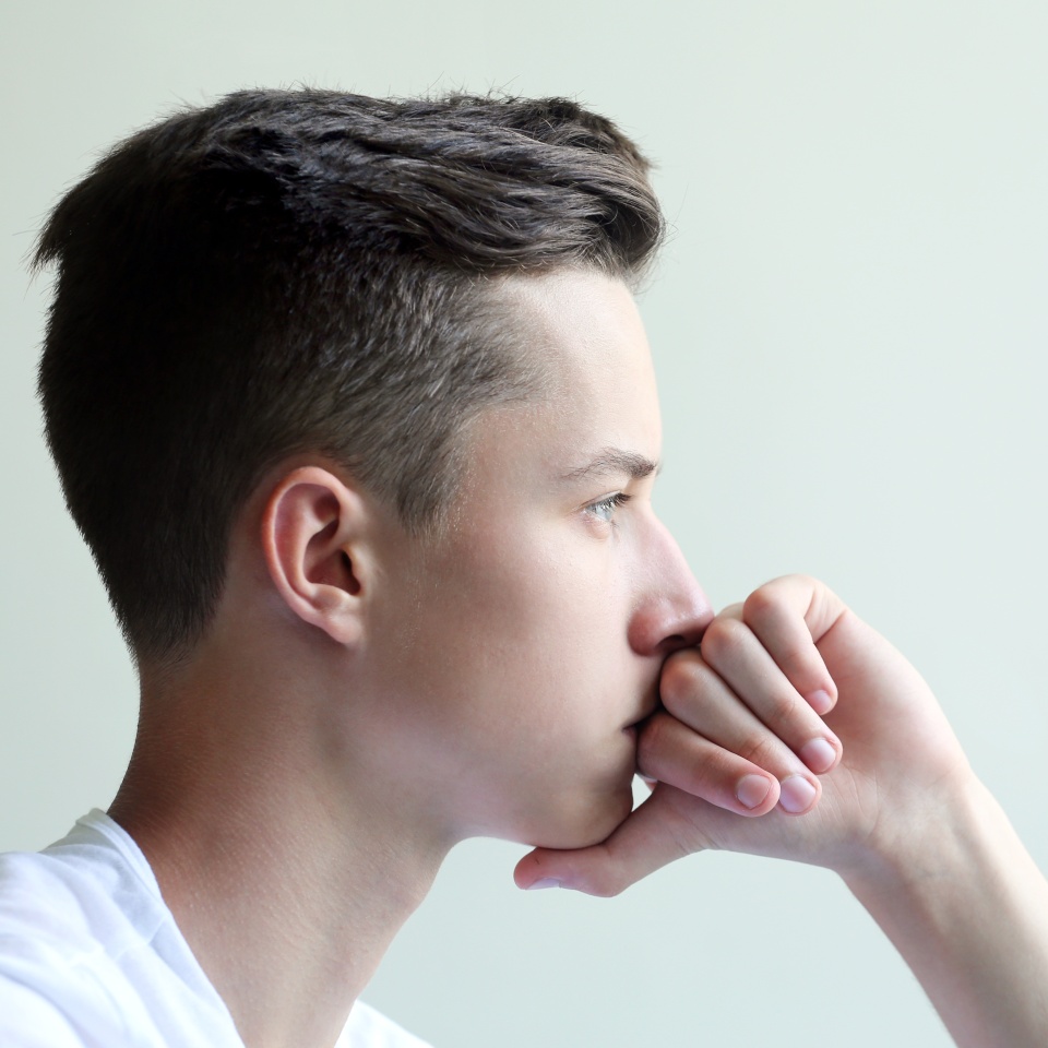 Thoughtful and looking young man with hand