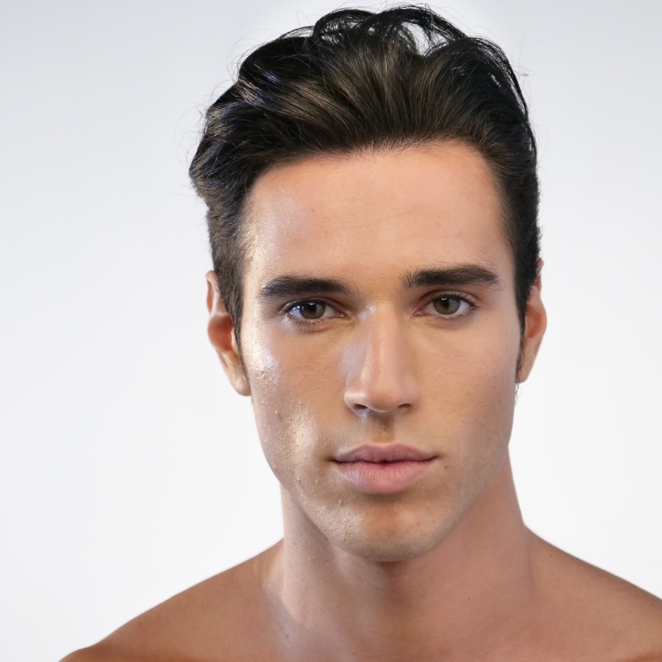 Portrait of a beautiful smiling man showing white teeth looking into camera or making faces of doubt or blunders with perfect skin and combed hair.